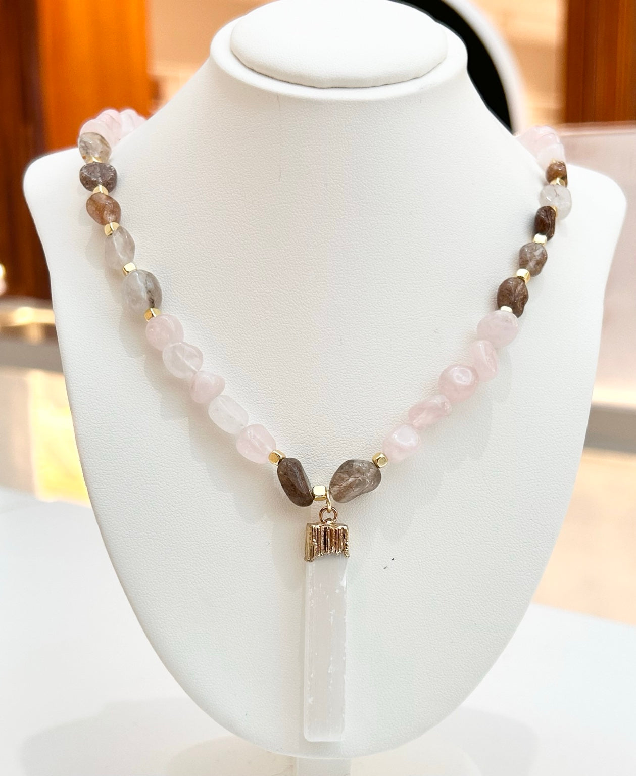 
                  
                    Rosamira mixed Rose Quartz selenite stick necklace displayed on a jewellery bust
                  
                