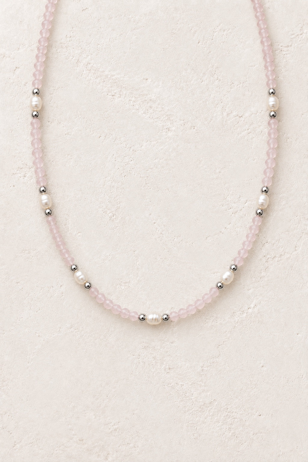 Rosavelle Rose Quartz silver-detail necklace with pearl accents on a neutral background