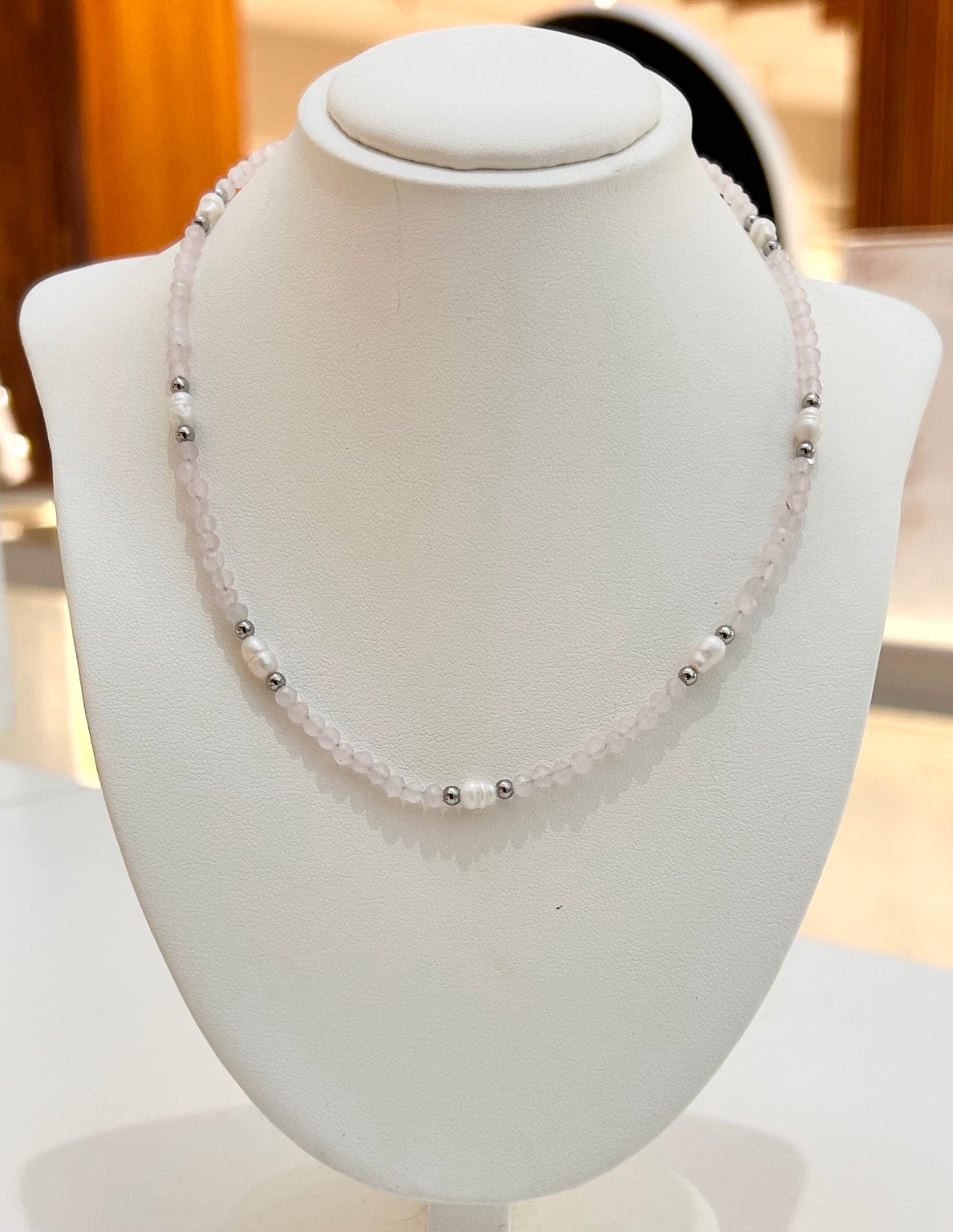 
                  
                    Rosavelle Rose Quartz silver-detail waterproof necklace displayed on a jewellery bust
                  
                