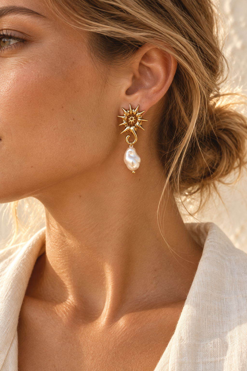 Model wearing Solana gold sunburst and pearl drop earring