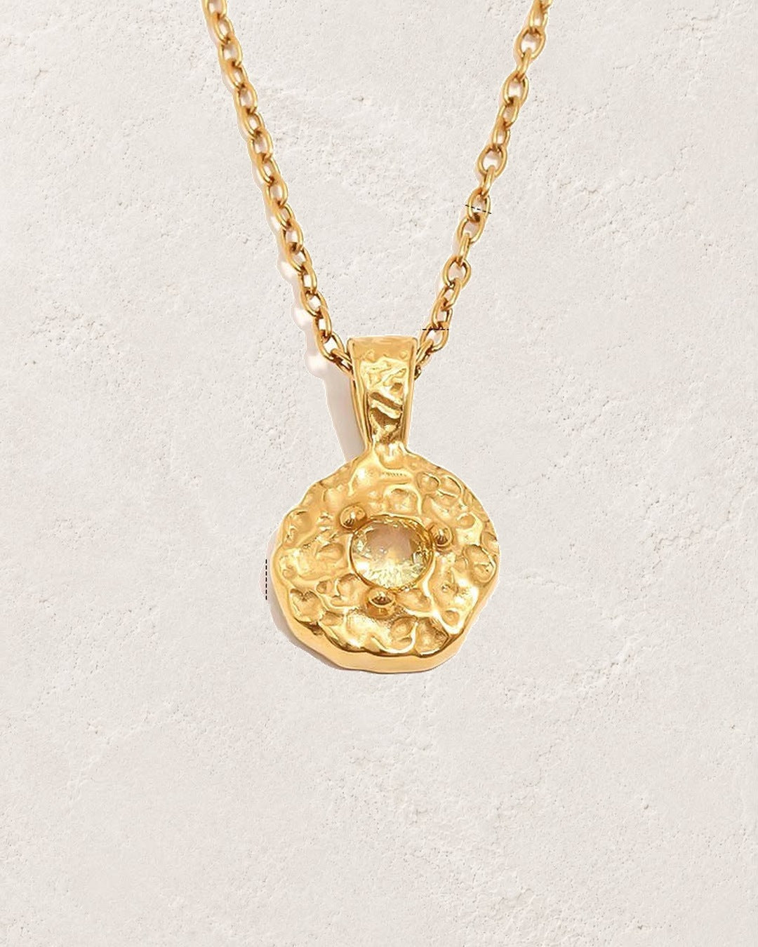 Solara April clear crystal birthstone necklace on cream plaster background