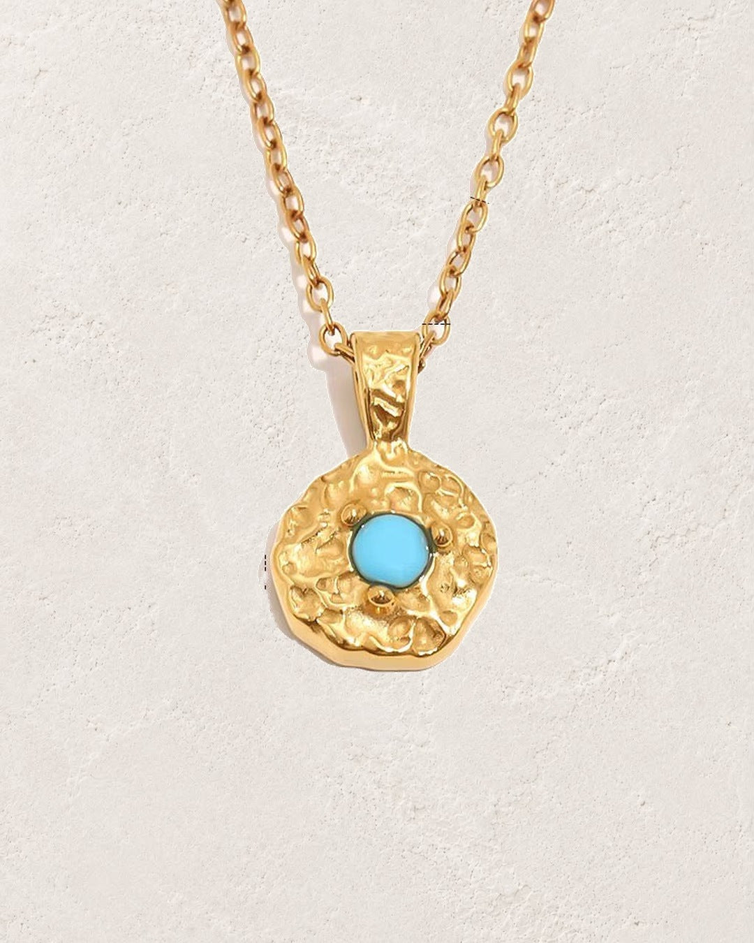 Solara December turquoise birthstone necklace on cream plaster background