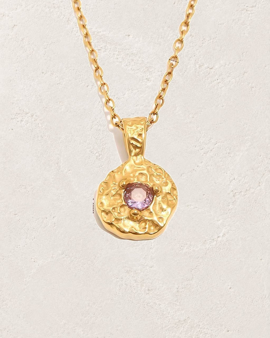 Solara February amethyst birthstone necklace on cream plaster background