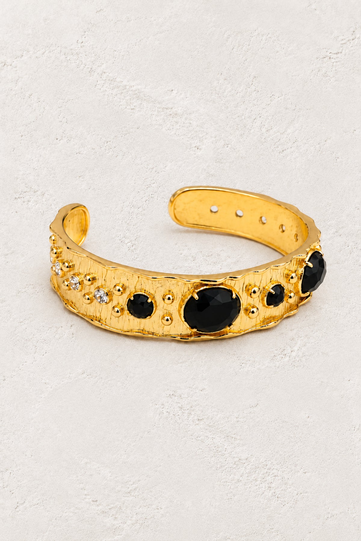 
                  
                    Black Obsidian Solara cuff bracelet on ivory plaster
                  
                