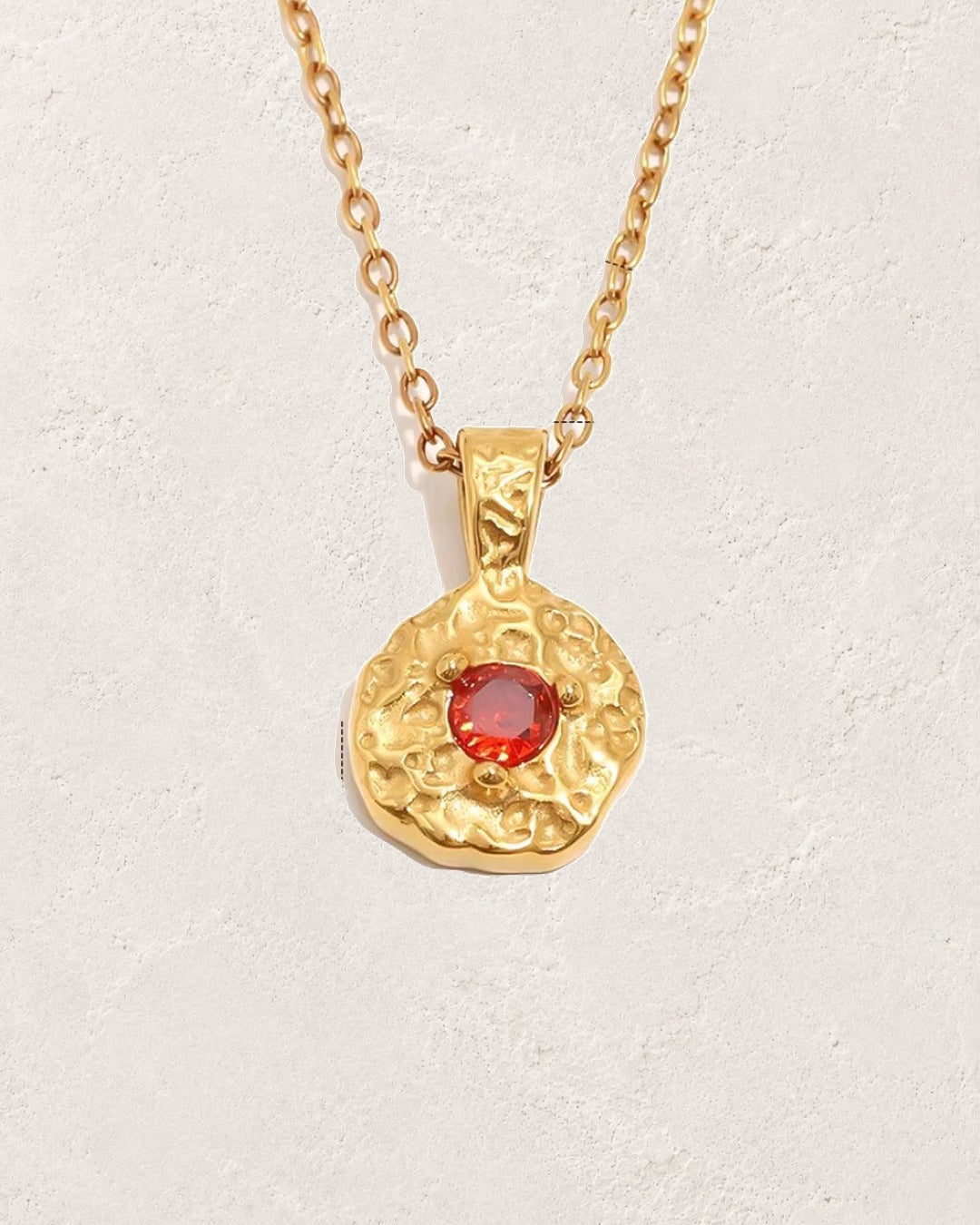 Solara July ruby birthstone necklace on cream plaster background
