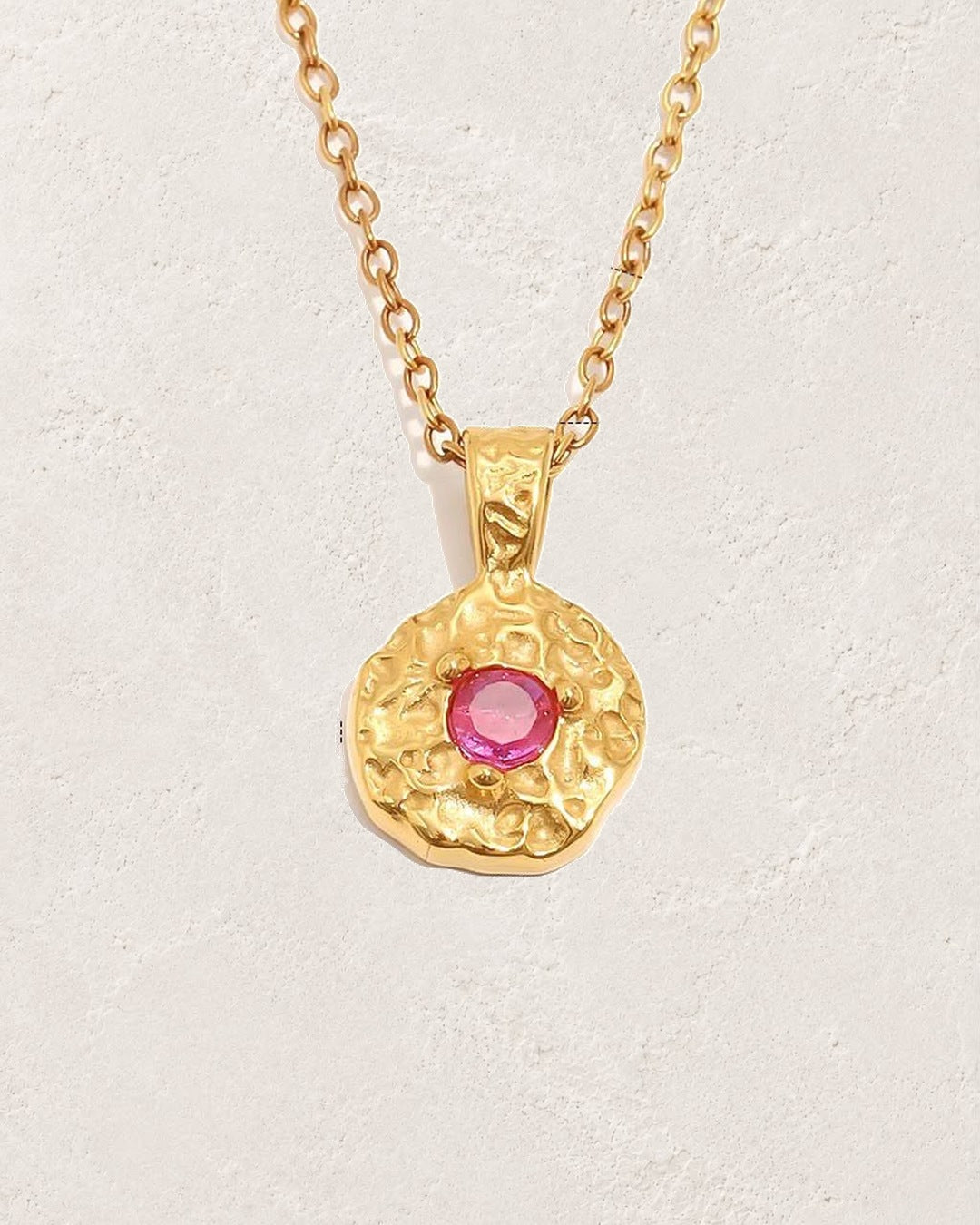Solara October pink tourmaline birthstone necklace on cream plaster background