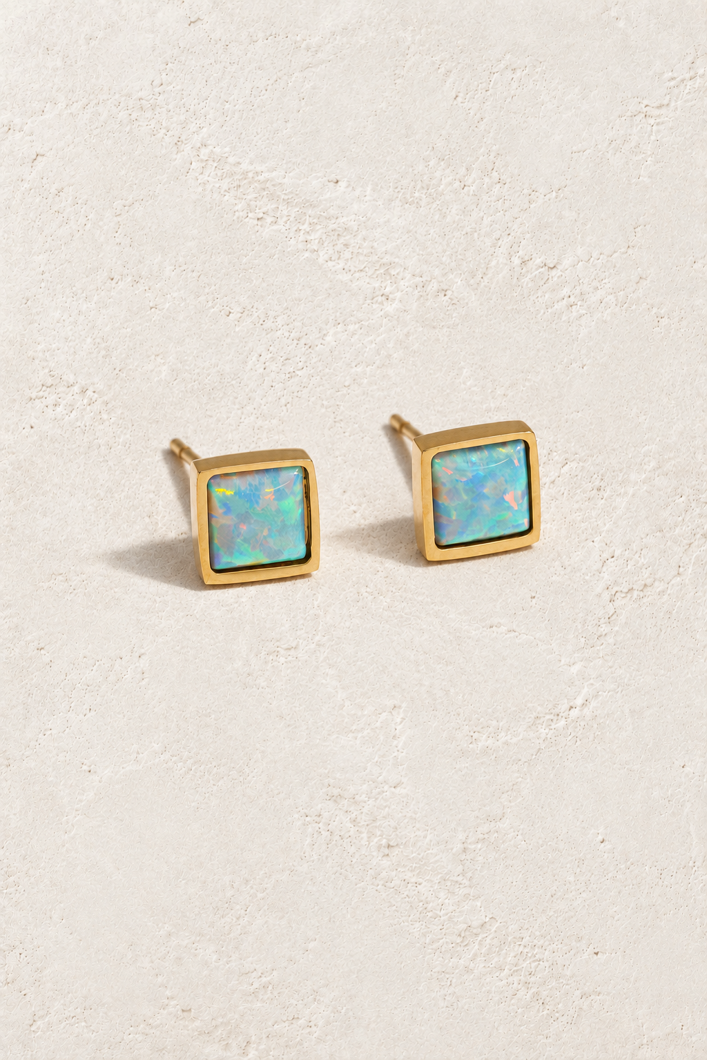 Square opal gold stud earrings on Boho & Mala ivory textured hero background