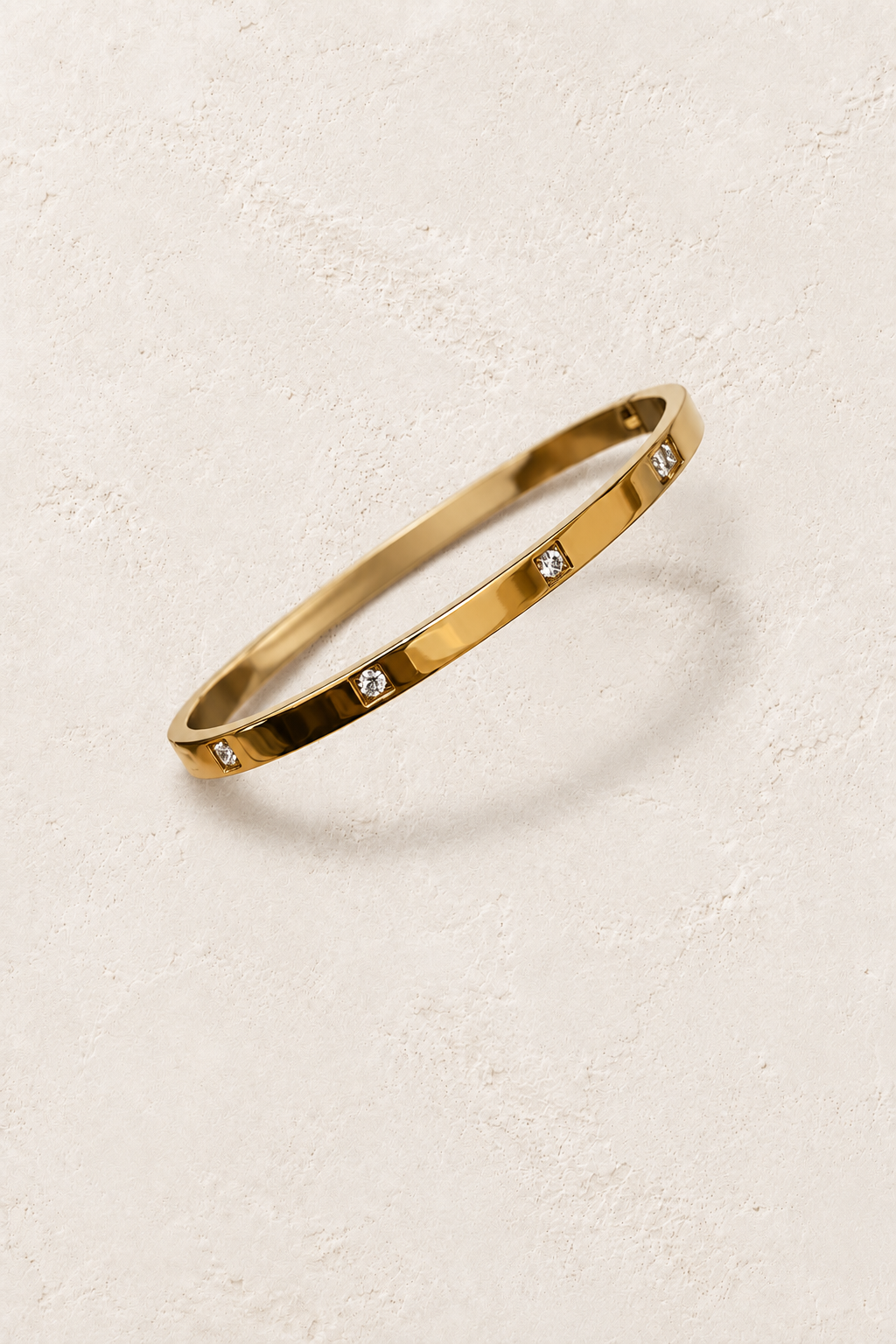 
                  
                    Stola Gold Crystal Station Bangle on cream beige textured background
                  
                