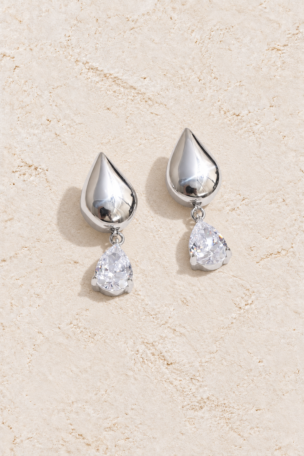 Silver Polished Teardrop Crystal Drop Earrings on cream plaster