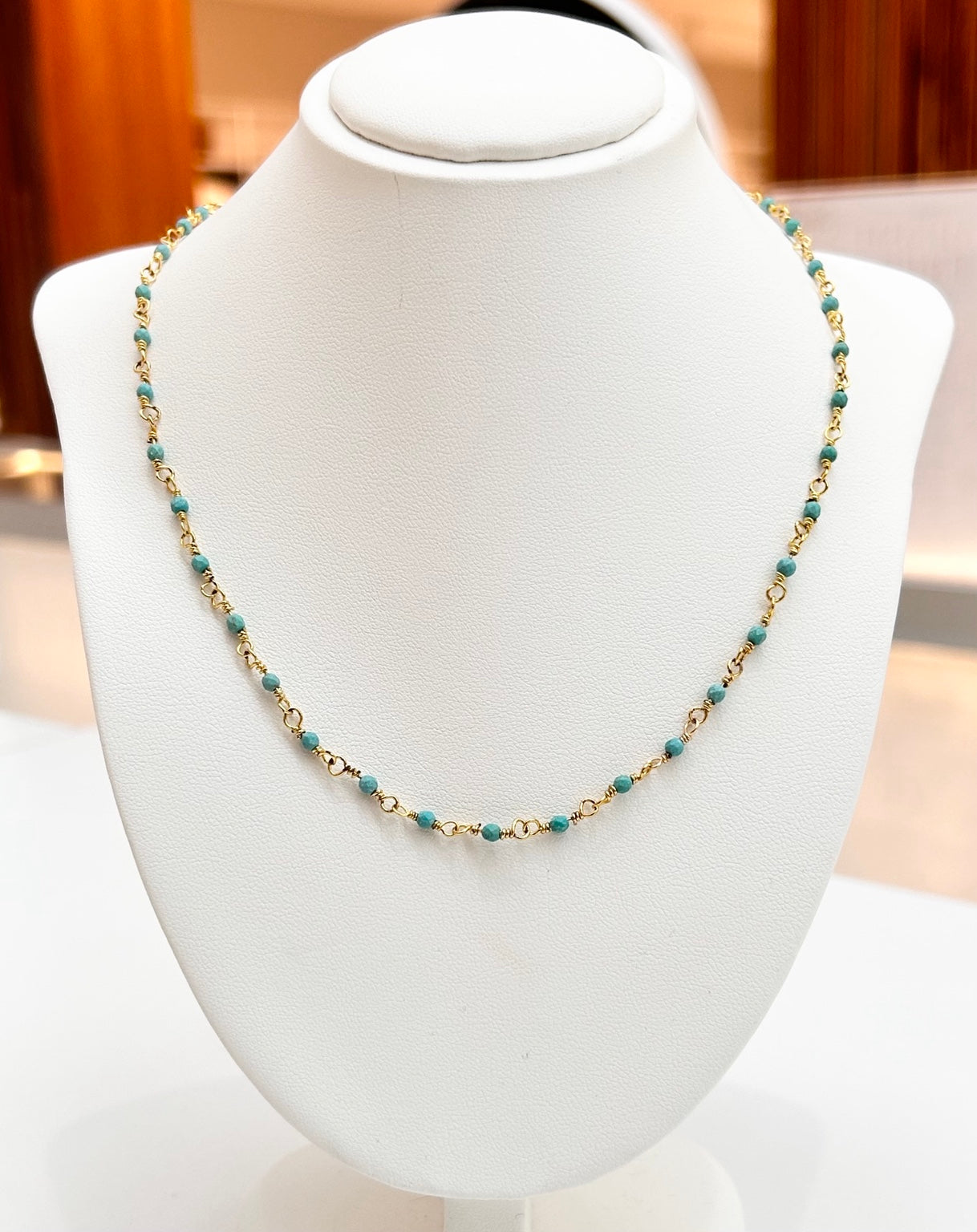 
                  
                    Tivara Turquoise gold-plated gemstone necklace displayed on a jewellery bust
                  
                
